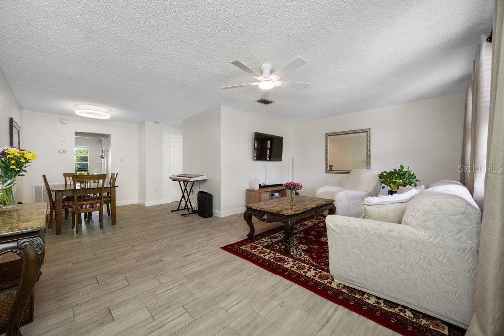 A living room with light tile floors, a dining area, and a ceiling fan — 5660 80TH STREET N UNIT B101, ST PETERSBURG, FL
