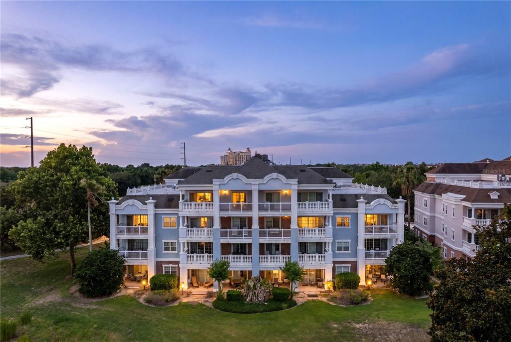 An aerial view of a multi-story apartment building with balconies and a landscaped lawn — 1100 SUNSET VIEW CIRCLE UNIT 204, REUNION, FL