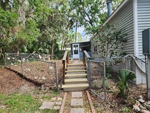 A wooden staircase leads to a screened porch on the side of a house — 5550 S CORAL BELLS AVENUE, HOMOSASSA, FL