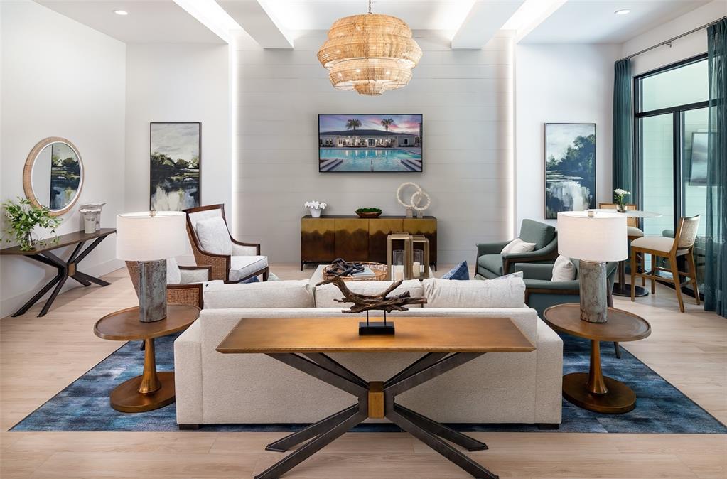 A modern living room features a sofa, armchairs, a central chandelier, and a wall-mounted television — 14370 FL-64 ROAD UNIT C1.1, BRADENTON, FL