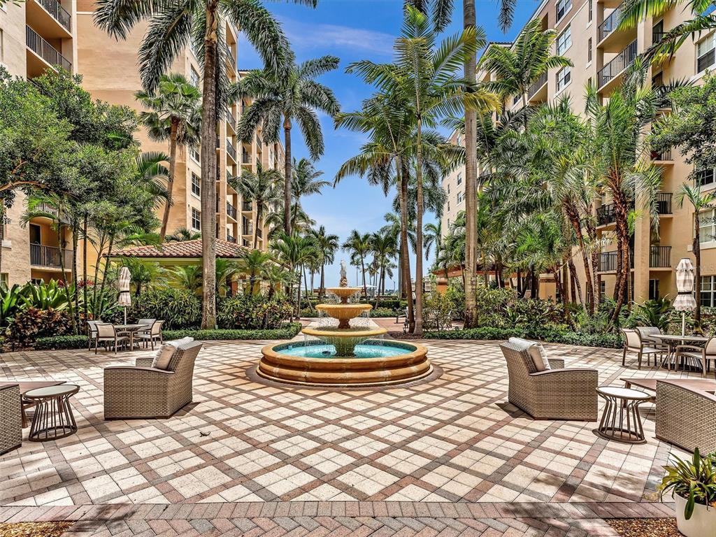 A stone-paved courtyard features a tiered fountain surrounded by palm trees and outdoor seating — 1801 N FLAGLER DRIVE UNIT 416, WEST PALM BEACH, FL