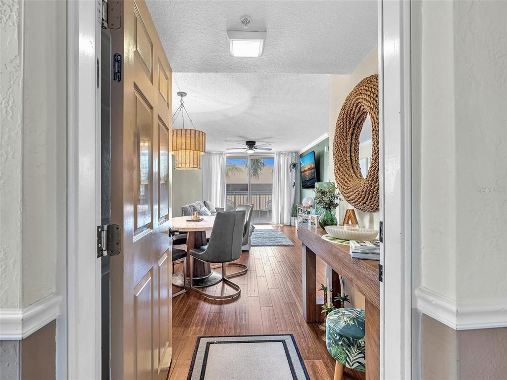 A view through an open door into a dining and living area with wood flooring — 1801 N FLAGLER DRIVE UNIT 416, WEST PALM BEACH, FL