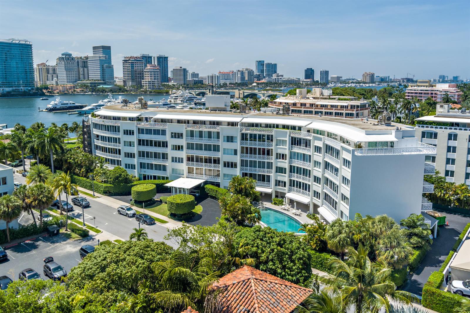 An aerial view of a white multi-story apartment building with a pool and waterfront scenery — 389 S Lake Drive, Palm Beach FL 33480, PALM BEACH, FL
