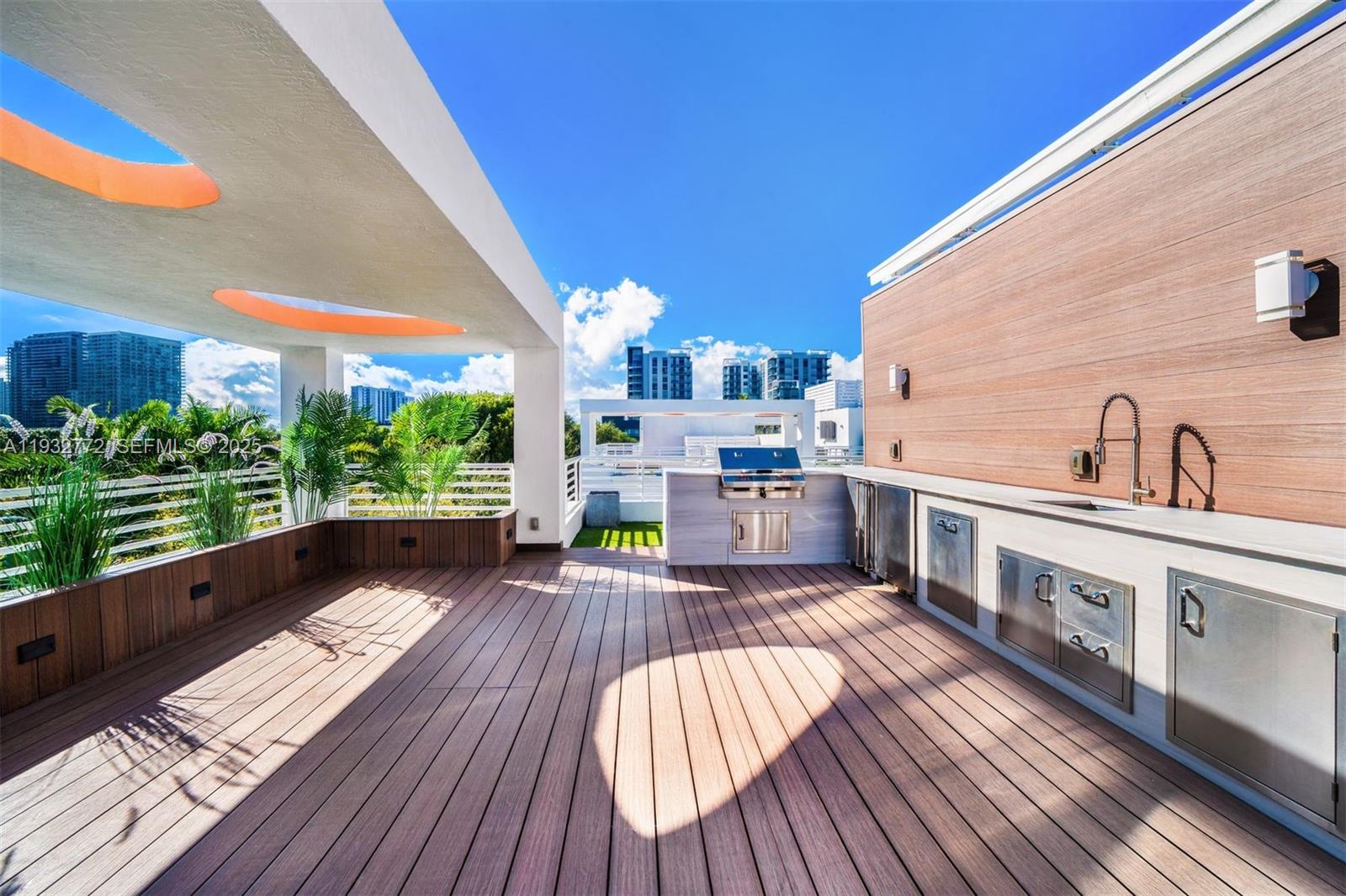 A rooftop terrace features a wooden deck, an outdoor kitchen, and a covered seating area — 455 NE 39th St # 202, Miami FL 33137, MIAMI, FL