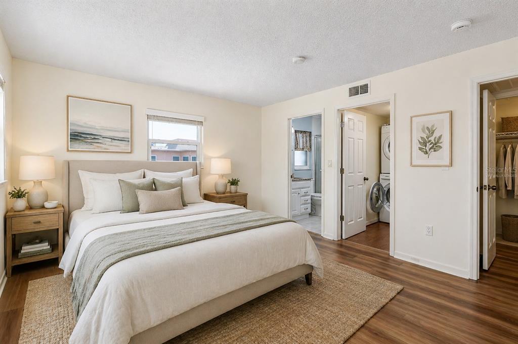 A kitchen features white cabinets, stainless steel appliances, granite countertops, and a tile backsplash — 7001 PLACE DE LA PAIX UNIT 2A, SOUTH PASADENA, FL