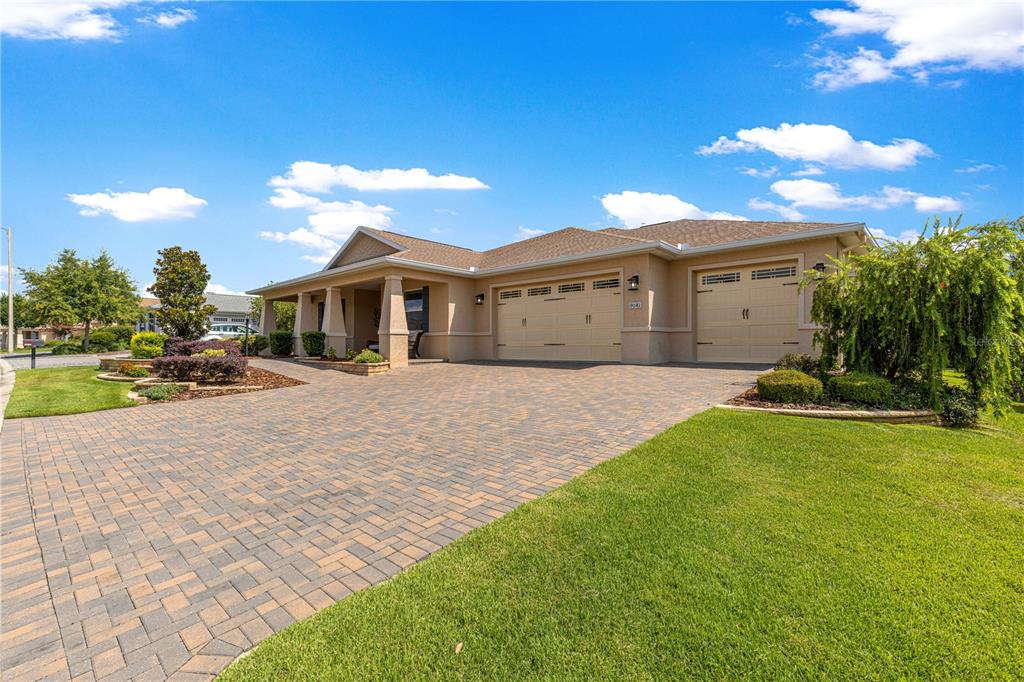 A single-story house with a paved driveway, a three-car garage, and a covered front porch — 9041 SW 88TH PLACE, OCALA, FL