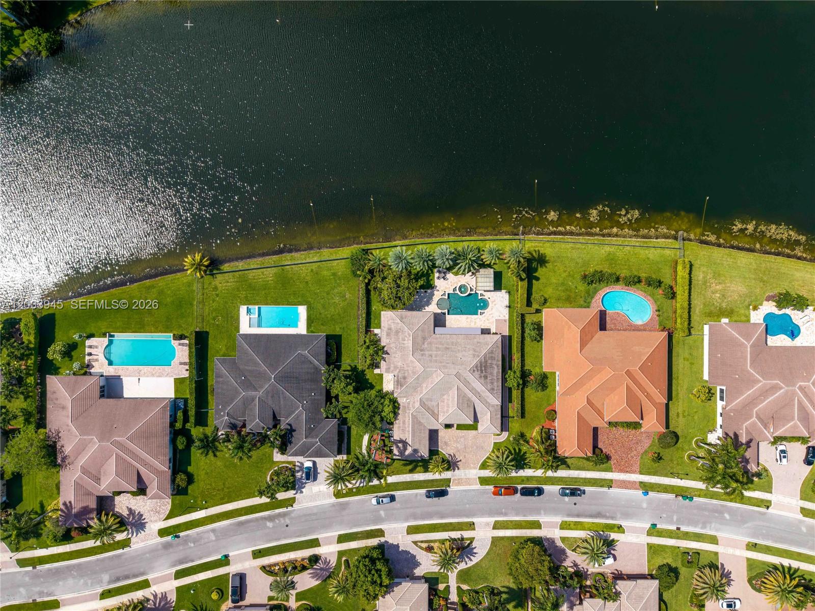 An aerial view shows several suburban houses with swimming pools situated along a large lake — 15253 SW 40th St # 0, Davie FL 33331, DAVIE, FL
