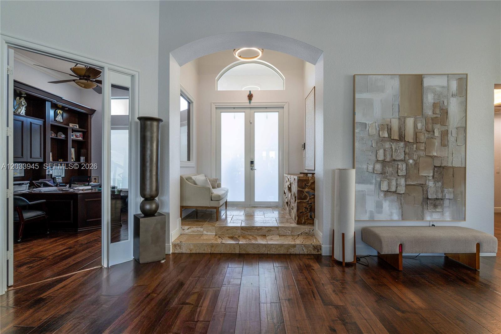 An entryway features a stone-tiled landing, double glass doors, and a large abstract wall painting — 15253 SW 40th St # 0, Davie FL 33331, DAVIE, FL