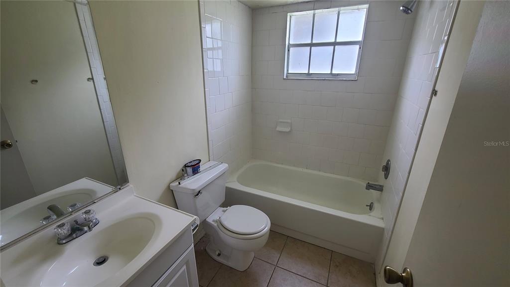 A bathroom features a white vanity, a toilet, and a bathtub with white wall tiles — 454 FAIRWAYS CIRCLE UNIT B102, OCALA, FL