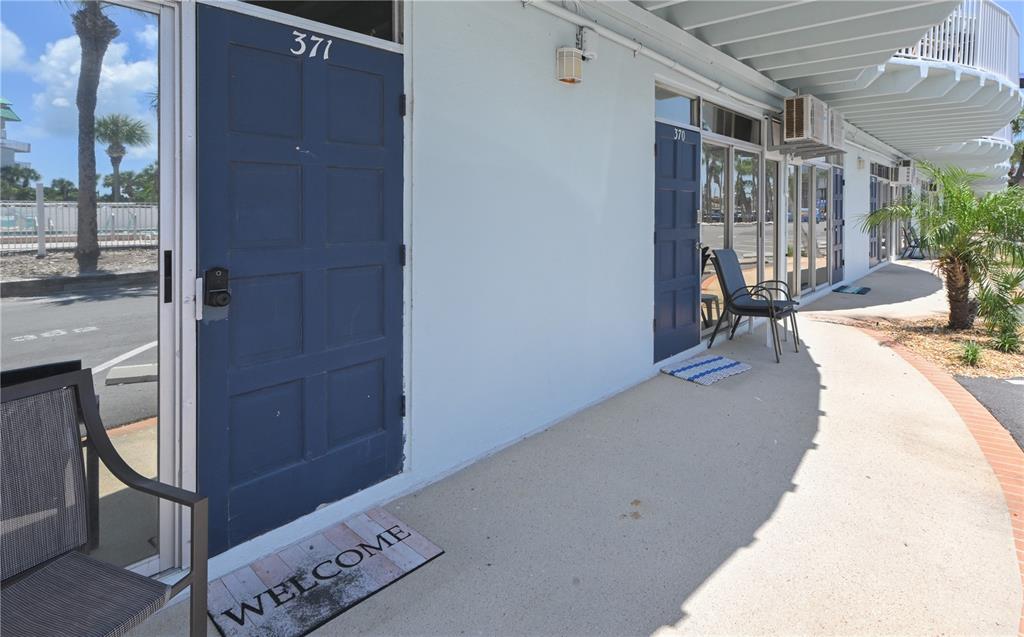 A row of blue doors with unit numbers on a concrete walkway outside a building — 18399 GULF BOULEVARD UNIT 371, INDIAN ROCKS BEACH, FL