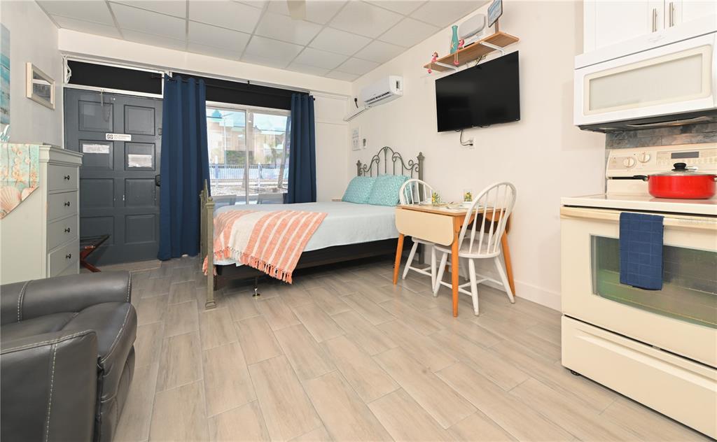 A studio apartment features a bed, a small dining table, a kitchen area, and tiled floors — 18399 GULF BOULEVARD UNIT 371, INDIAN ROCKS BEACH, FL