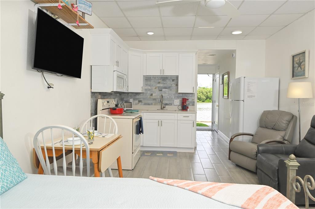A studio apartment features a small kitchen, dining area, and living space with water views — 18399 GULF BOULEVARD UNIT 371, INDIAN ROCKS BEACH, FL