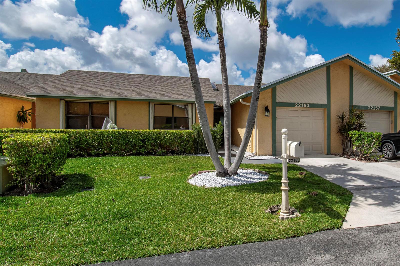 A single-story house with a tan stucco exterior, a garage, and a palm tree — 22163 Thomas Terrace, Boca Raton FL 33433, BOCA RATON, FL