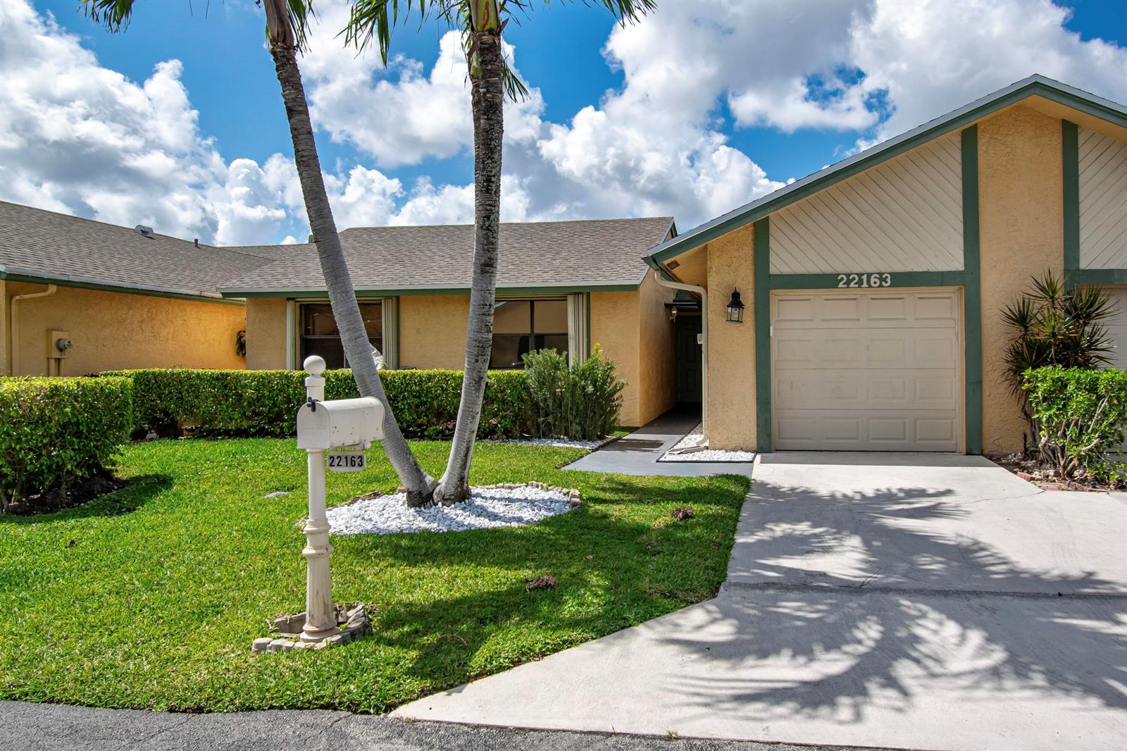 A single-story house with a beige stucco exterior, green trim, and a concrete driveway — 22163 Thomas Terrace, Boca Raton FL 33433, BOCA RATON, FL