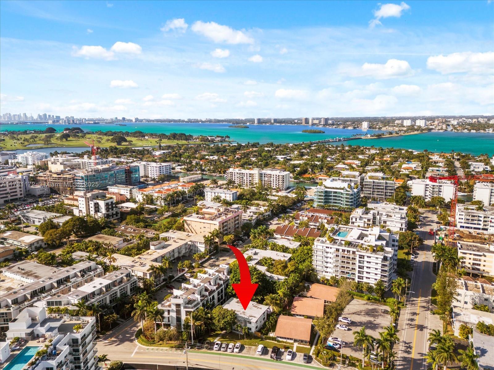 An aerial view shows a low-rise residential building marked by a red arrow — 9950 E Bay Harbor Dr, Bay Harbor Islands FL 33154, BAY HARBOR ISLANDS, FL