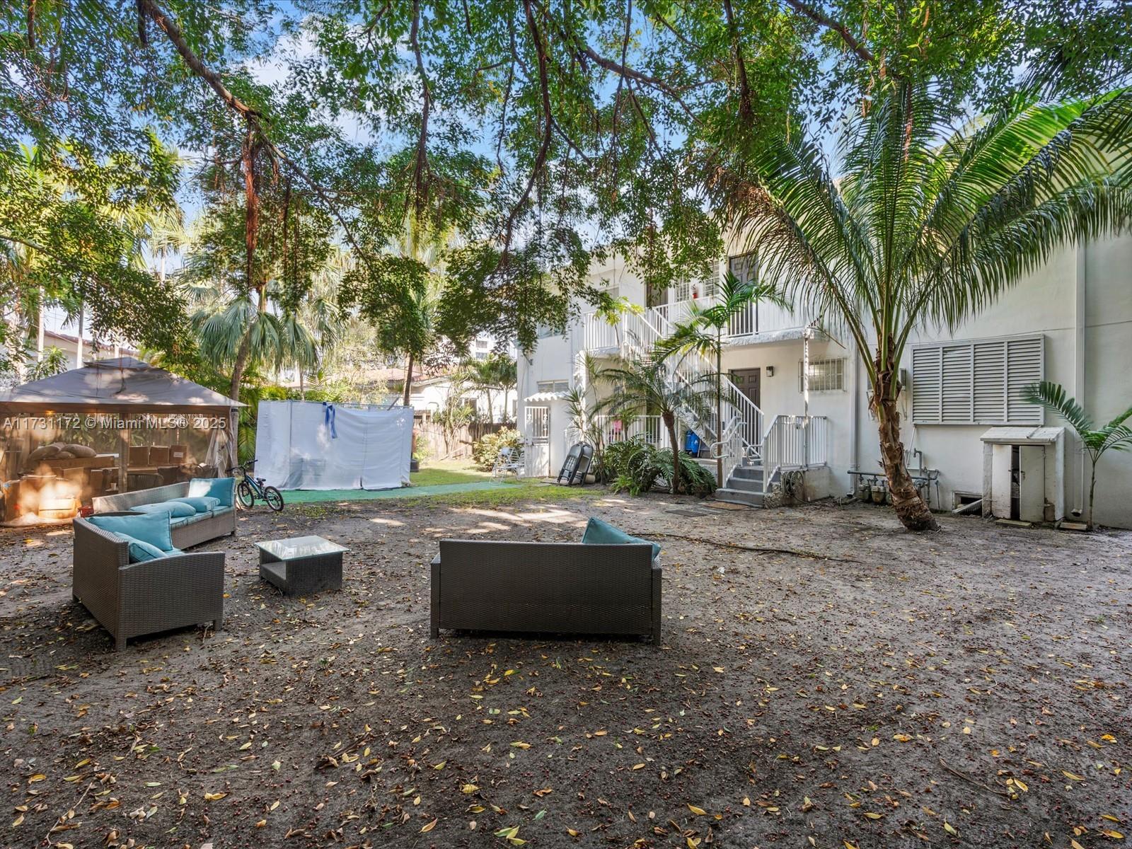 A backyard area features patio furniture, a gazebo, and a multi-story white building — 9950 E Bay Harbor Dr, Bay Harbor Islands FL 33154, BAY HARBOR ISLANDS, FL