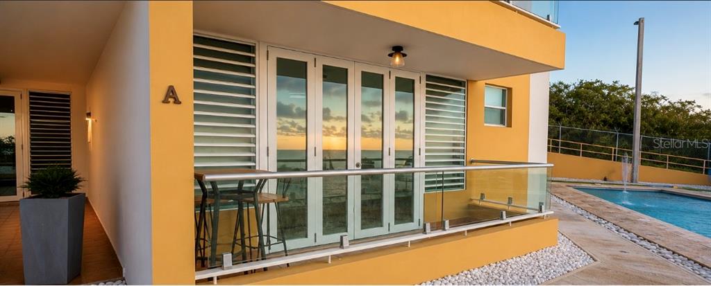 A yellow building exterior features a glass-railed balcony with a small table and chairs — SR 3301 k2 h6 int COMBATE BOQUERON WARD ST COND COSTA DEL MAR UNIT 102 A, BOQUERON, PR