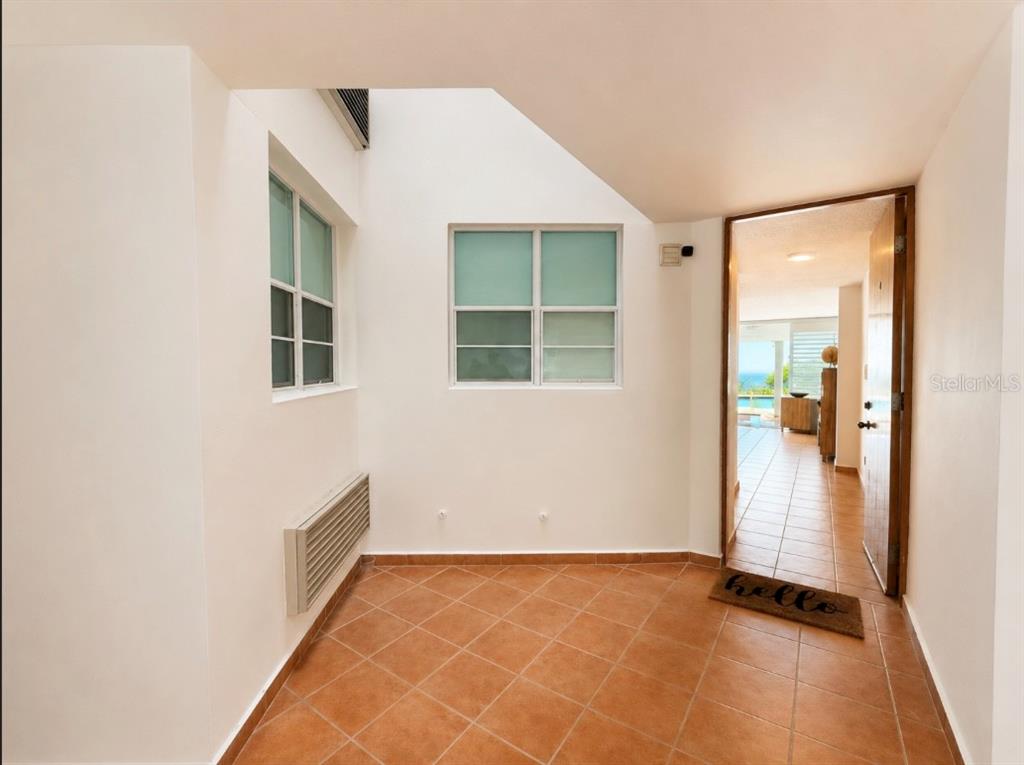 An entryway with terracotta tile flooring leads into a bright room with ocean views — SR 3301 k2 h6 int COMBATE BOQUERON WARD ST COND COSTA DEL MAR UNIT 102 A, BOQUERON, PR