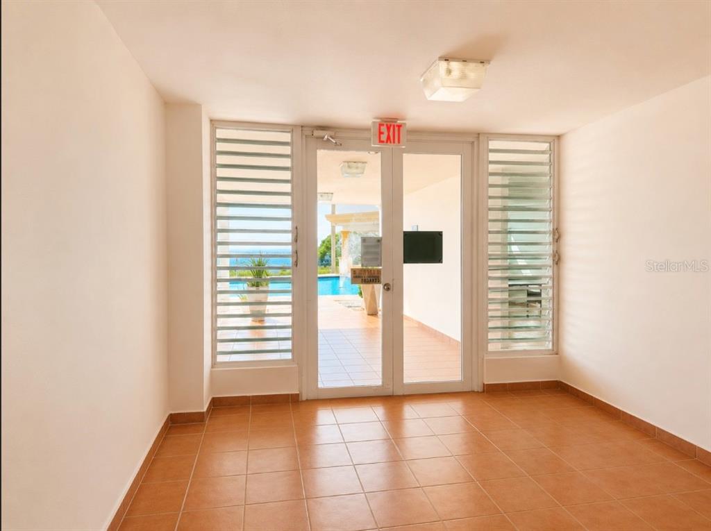 An indoor tiled room leads through glass doors to an outdoor pool and ocean view — SR 3301 k2 h6 int COMBATE BOQUERON WARD ST COND COSTA DEL MAR UNIT 102 A, BOQUERON, PR