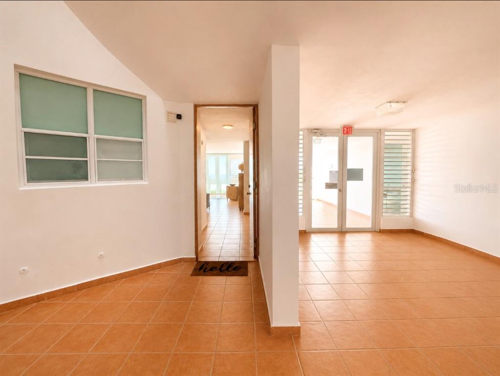 An interior view shows a tiled entryway leading to a hallway and a glass exit door — SR 3301 k2 h6 int COMBATE BOQUERON WARD ST COND COSTA DEL MAR UNIT 102 A, BOQUERON, PR