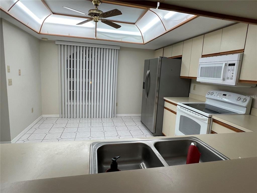 A kitchen with light-colored cabinets, stainless steel appliances, and a tiled floor — 751 PINELLAS BAYWAY S UNIT 305, TIERRA VERDE, FL