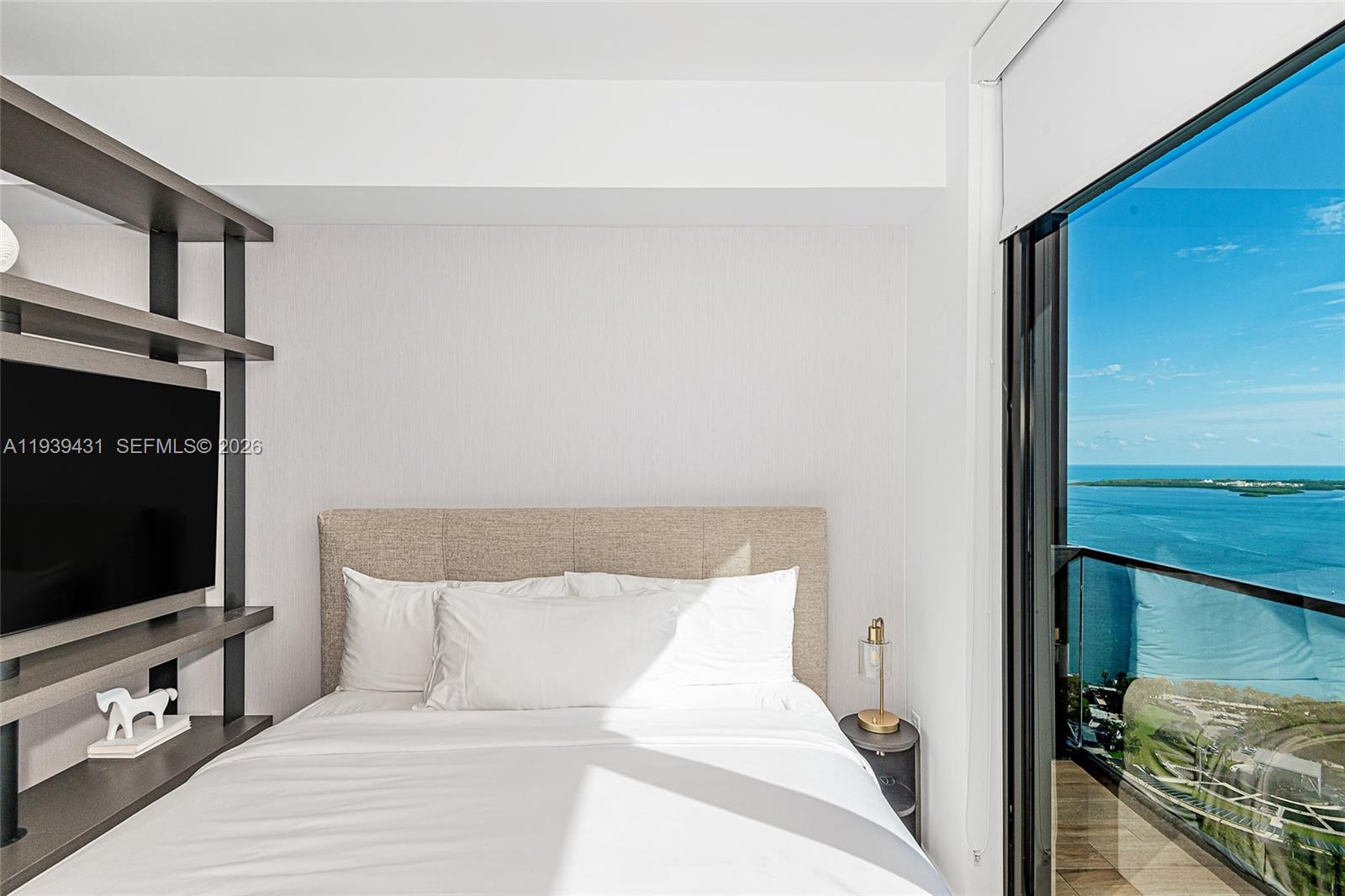 A bedroom features a bed, a wall-mounted television, and a balcony with ocean views — 398 NE 5th St # 4512, Miami FL 33132, MIAMI, FL