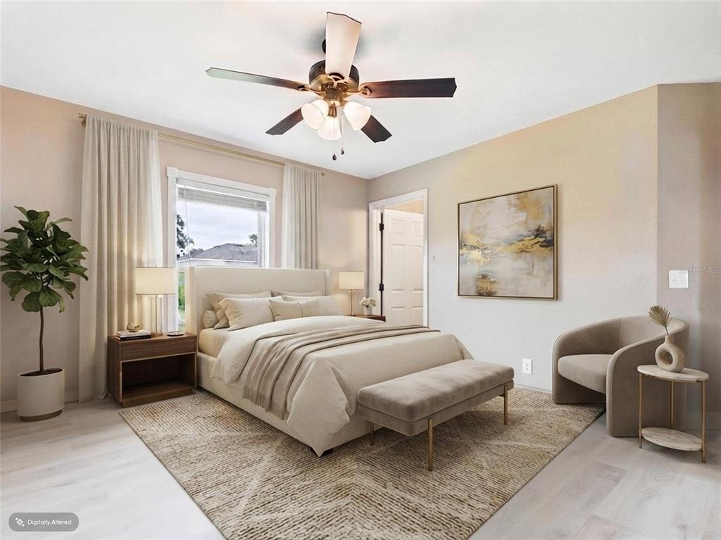 A bedroom features a bed with a neutral-toned headboard, a ceiling fan, and a rug — 15734 SW 46TH AVENUE ROAD, OCALA, FL