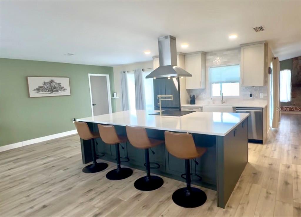 An entryway features a light-colored door, beige walls, and light wood-look flooring — 1861 WILLOW OAK DRIVE N, PALM HARBOR, FL