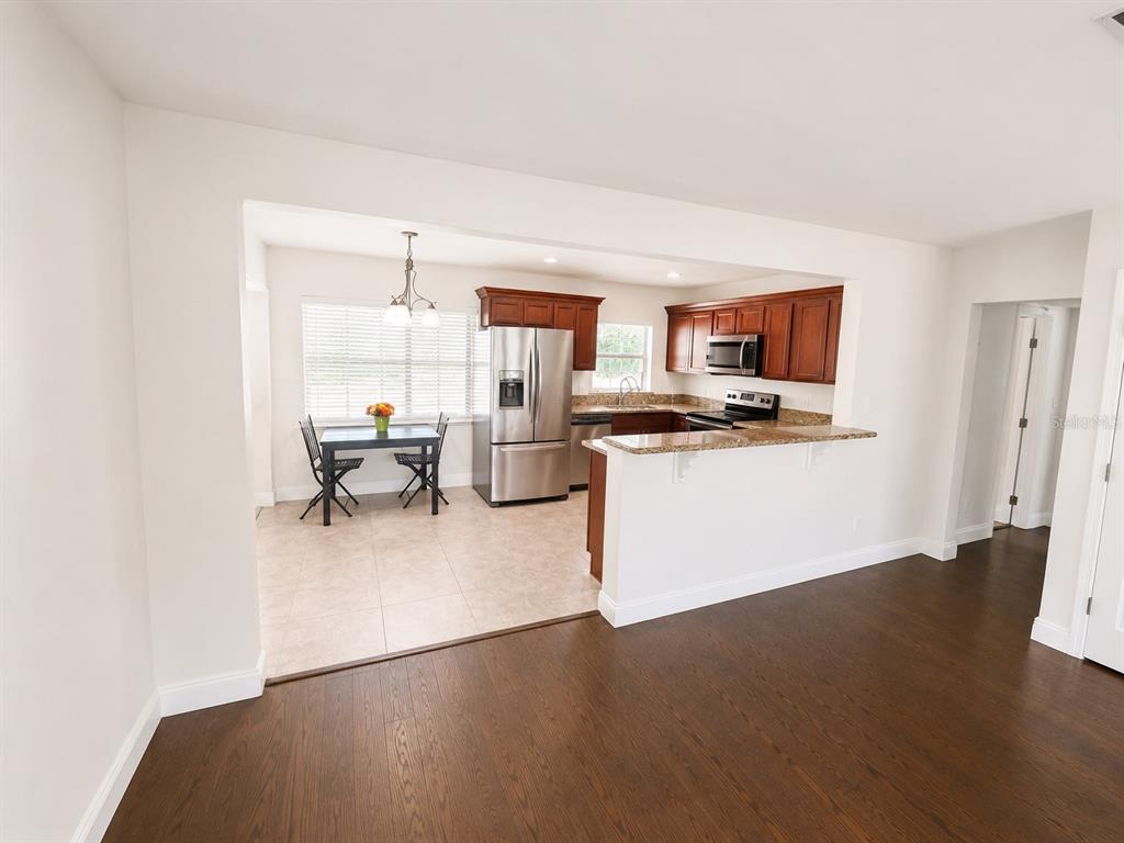 A kitchen with wood cabinets, stainless steel appliances, and a dining area with tile flooring — 616 ELLENDALE DRIVE, WINTER PARK, FL