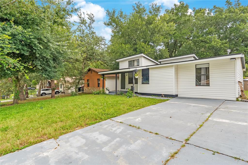 A white single-story house with a concrete driveway and a large front lawn with trees — 415 S LANCELOT AVENUE, ORLANDO, FL