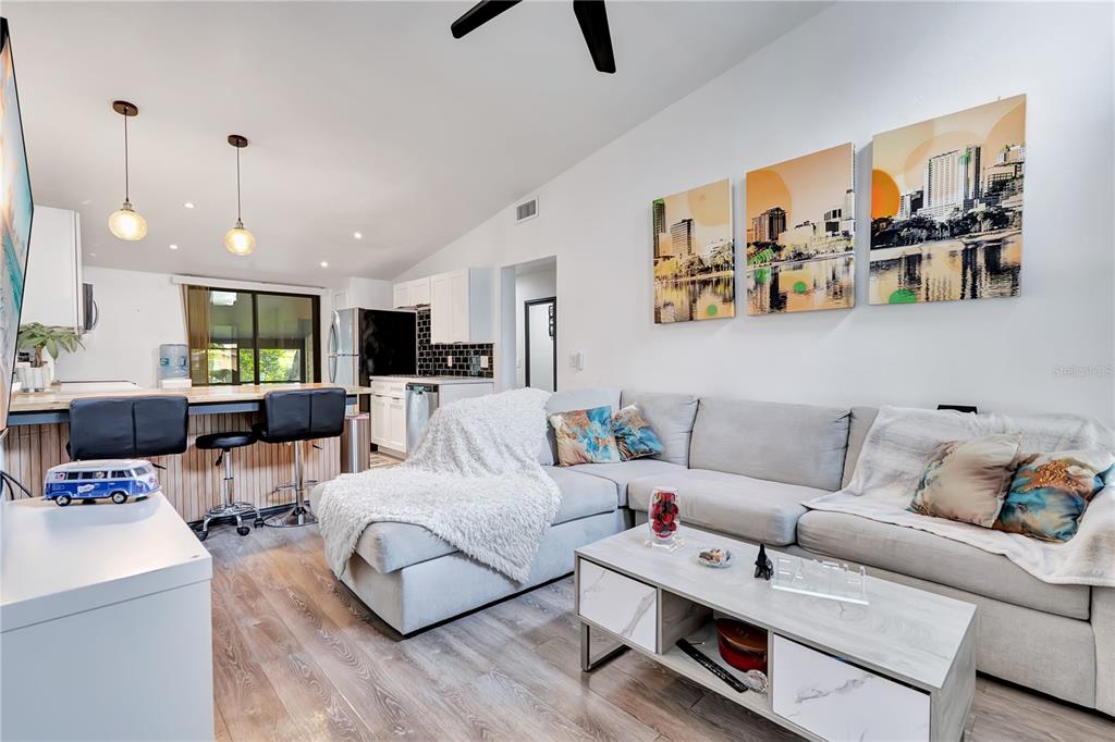 A living room features a grey sectional sofa, a coffee table, and an open kitchen — 415 S LANCELOT AVENUE, ORLANDO, FL