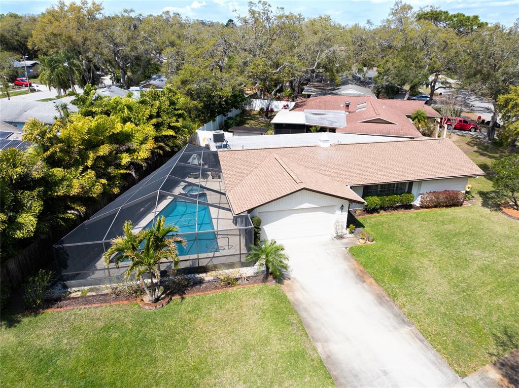 An aerial view of a single-story house with a screened-in pool and a concrete driveway — 1830 OAK FOREST DRIVE S, CLEARWATER, FL