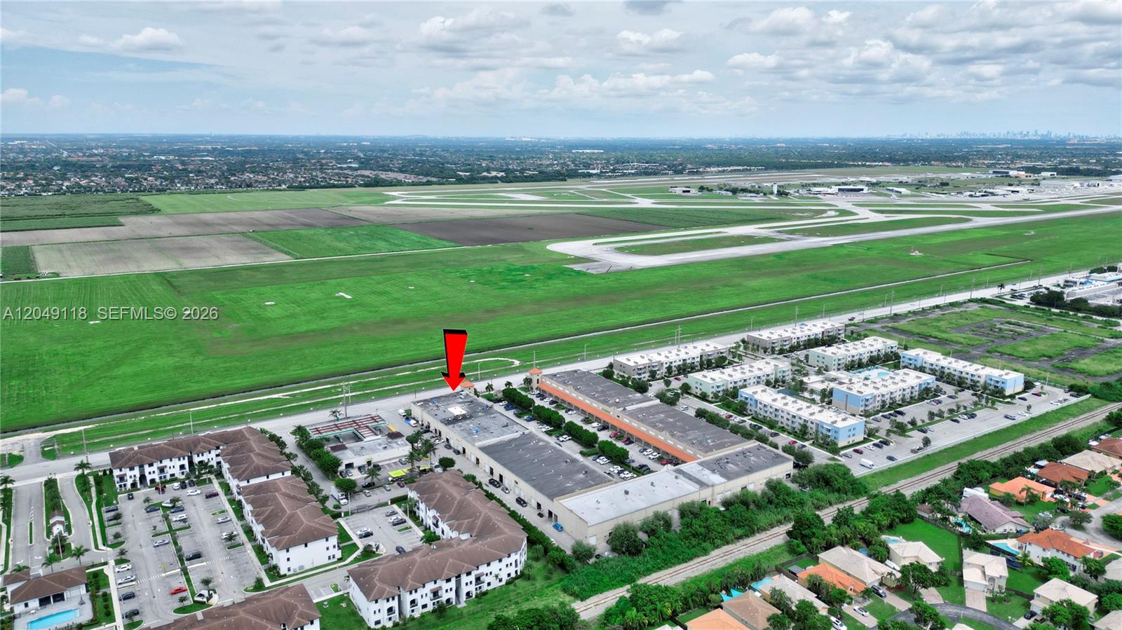 An aerial view shows a commercial building complex situated next to an airport runway — 15420 SW 136th St # 6, Miami FL 33196, MIAMI, FL