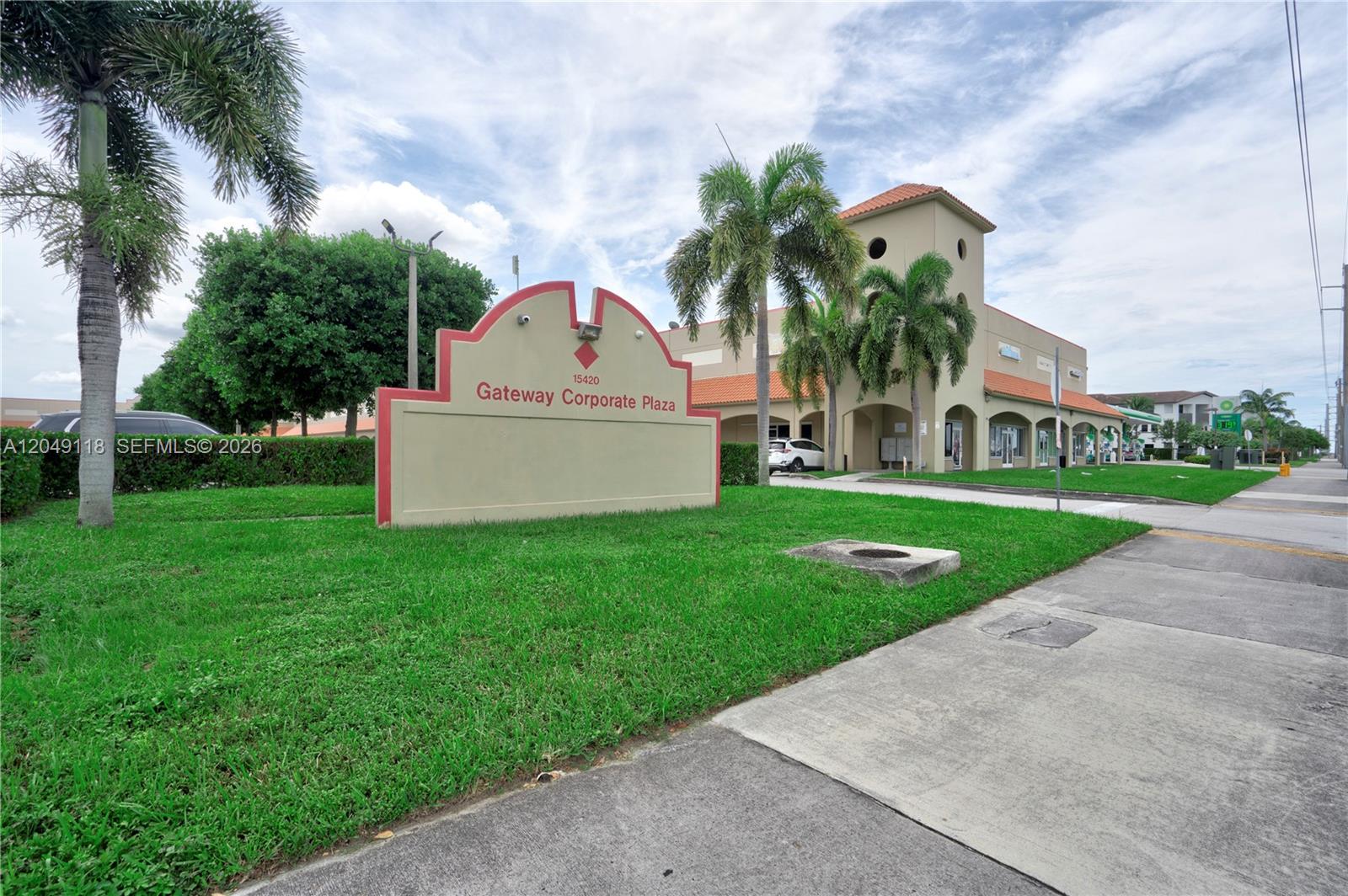A sign for Gateway Corporate Plaza stands on a grassy lawn in front of a building — 15420 SW 136th St # 6, Miami FL 33196, MIAMI, FL
