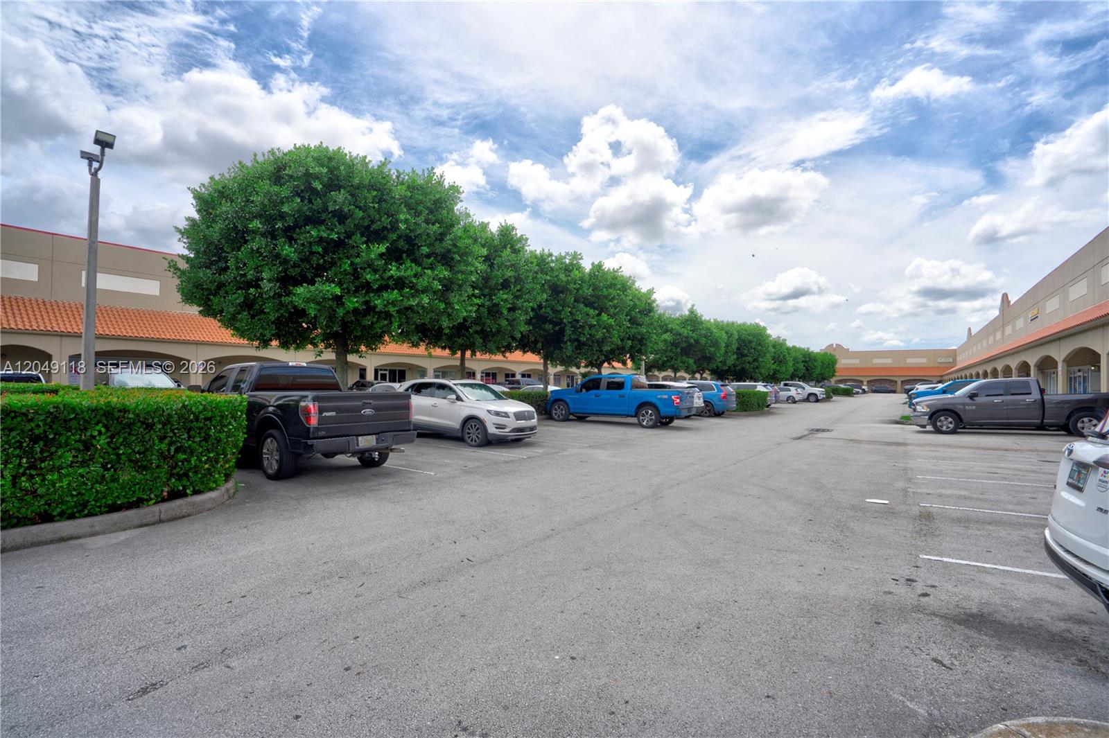 A parking lot sits in front of a commercial building with a row of trees — 15420 SW 136th St # 6, Miami FL 33196, MIAMI, FL