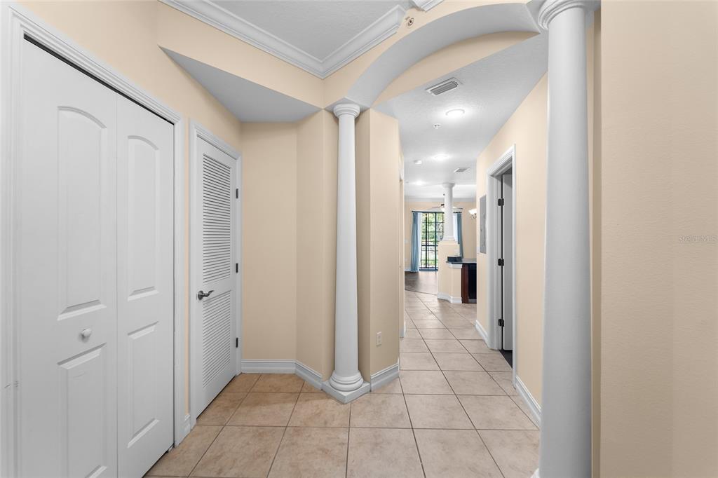 A tiled entryway features white columns, an arched ceiling, and doors leading to other rooms — 13941 CLUBHOUSE DRIVE UNIT 106, TAMPA, FL