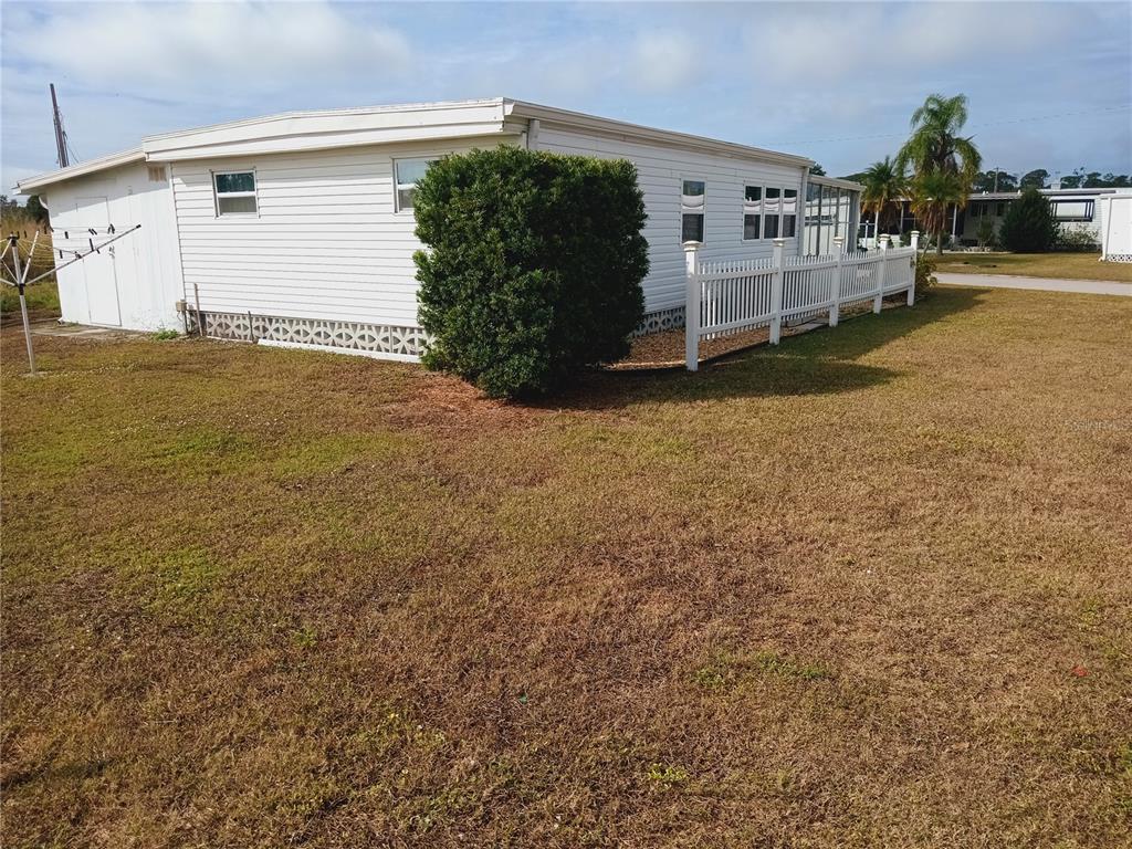 A white mobile home with a lattice skirting and a white picket fence exterior — 1580 BLIND BROOK DRIVE, SARASOTA, FL