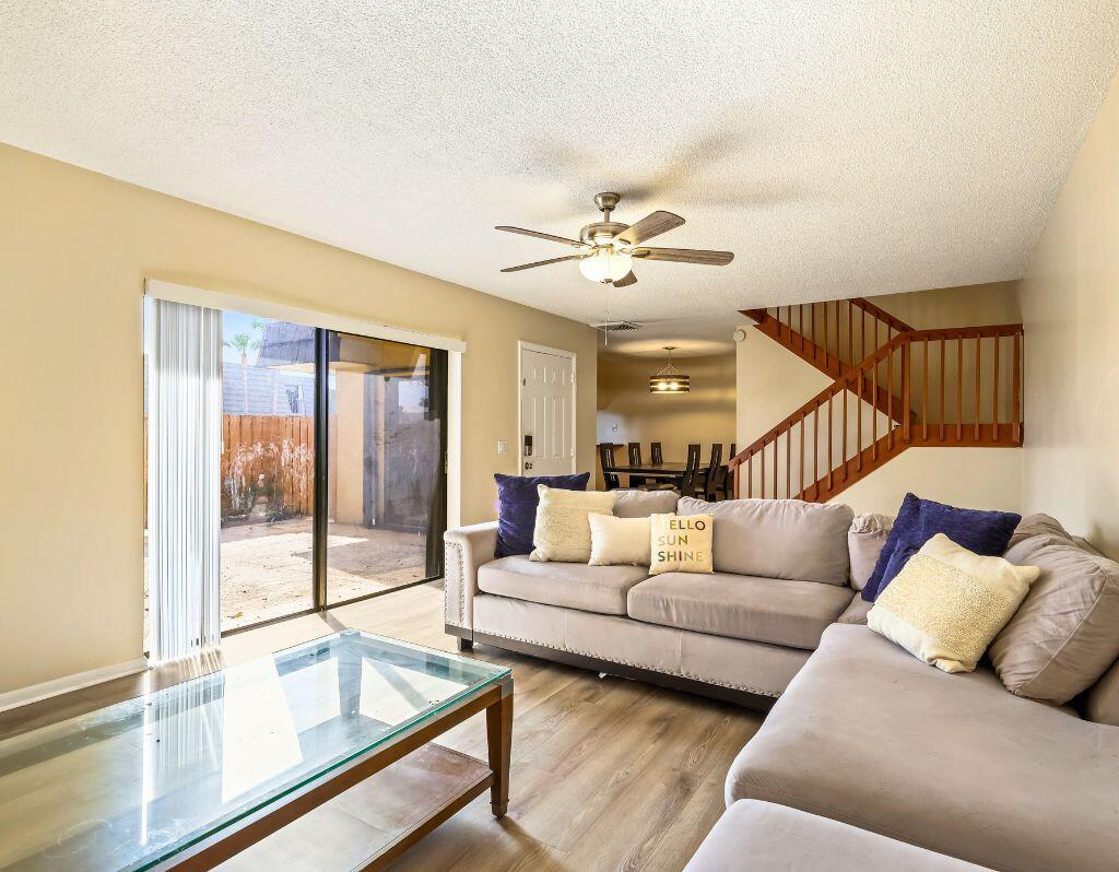 A living room with a grey sectional sofa, glass coffee table, and stairs to the right — 2229 22nd Way, West Palm Beach FL 33407, WEST PALM BEACH, FL