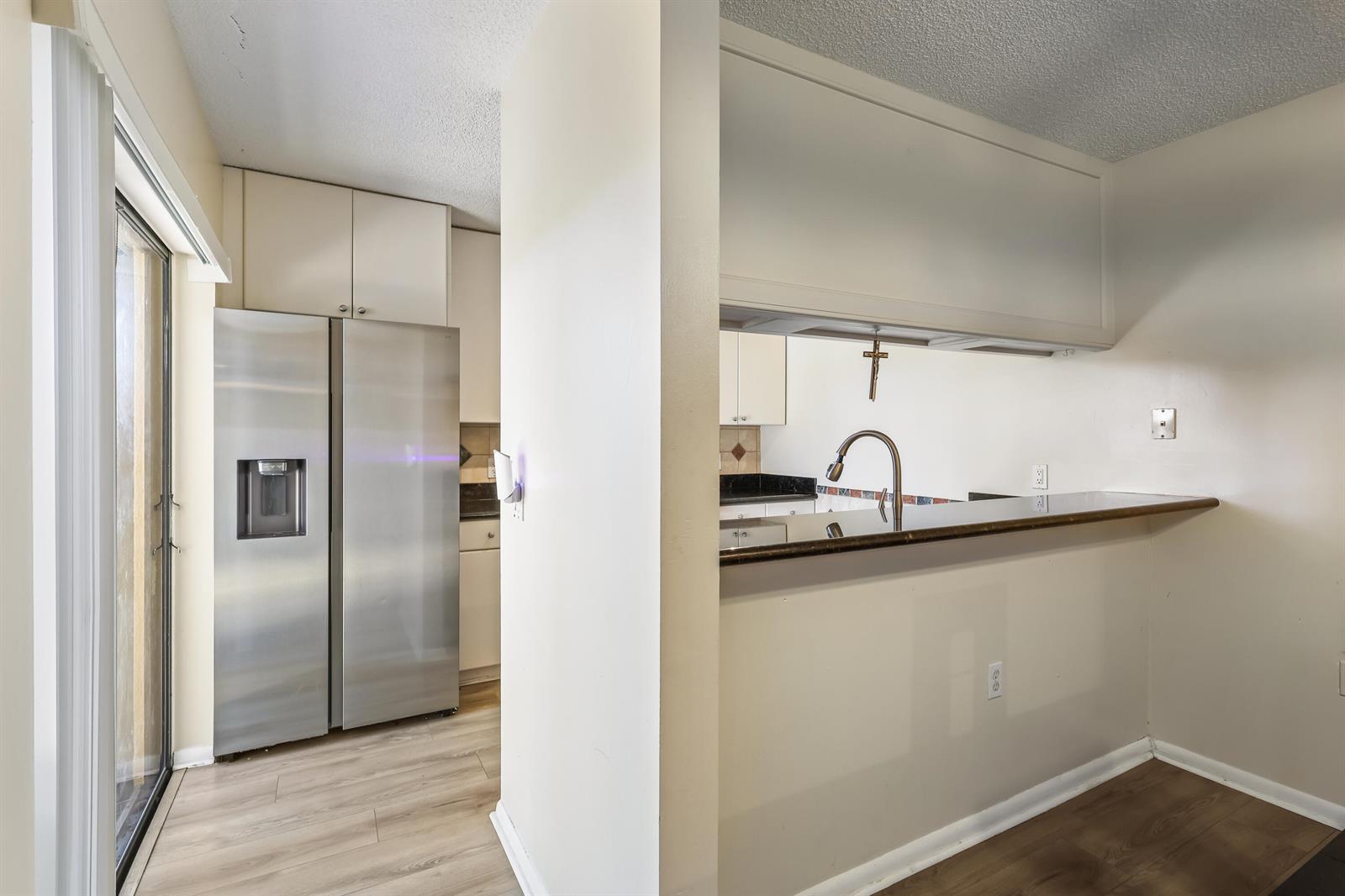 A kitchen features stainless steel appliances, a breakfast bar, and light-colored cabinetry — 2229 22nd Way, West Palm Beach FL 33407, WEST PALM BEACH, FL
