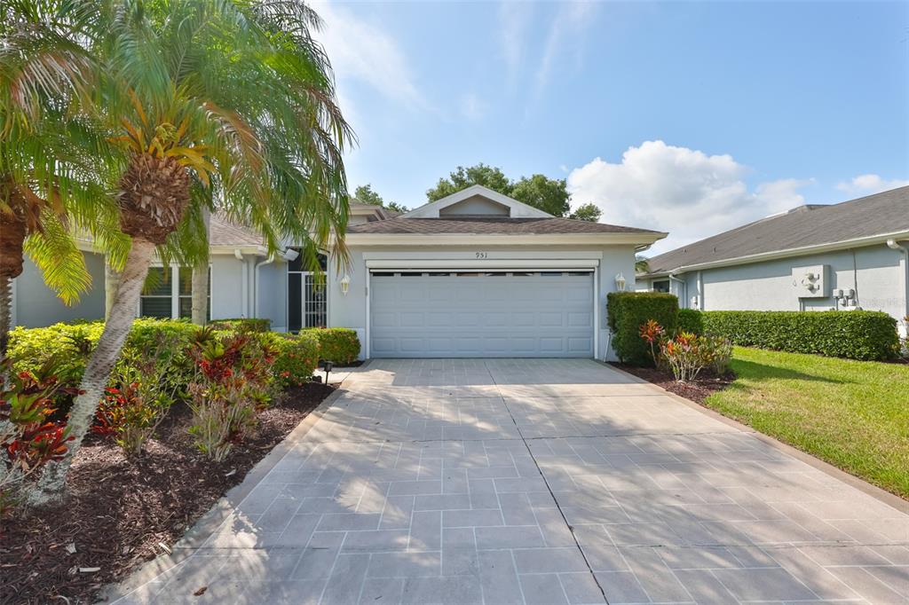 A single-story house with a light gray garage door and a paved driveway — 951 VILLEROY GREENS DRIVE, SUN CITY CENTER, FL