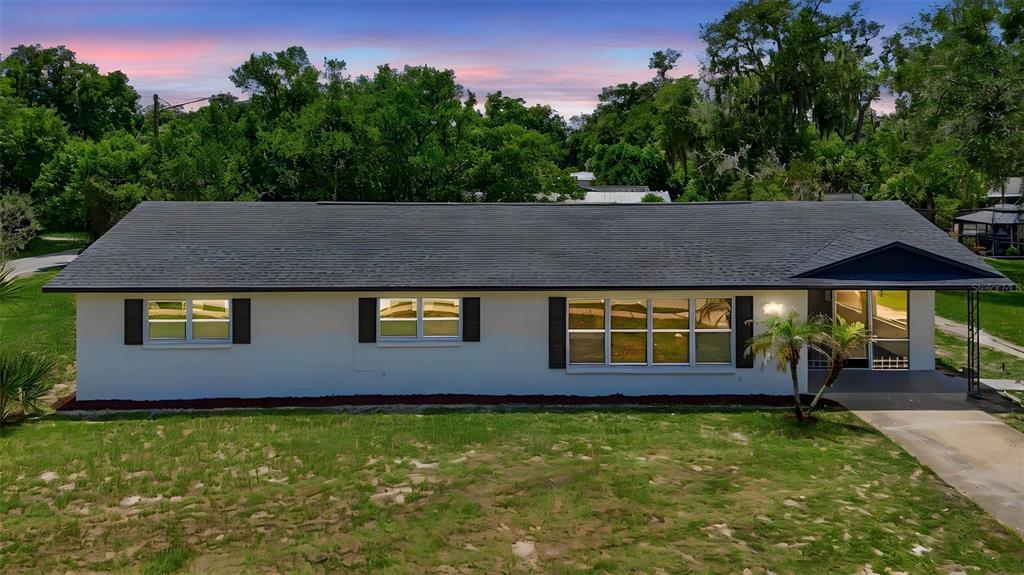 A single-story house with a white exterior, dark roof, and a front porch — 206 MARGARITA ROAD, DEBARY, FL