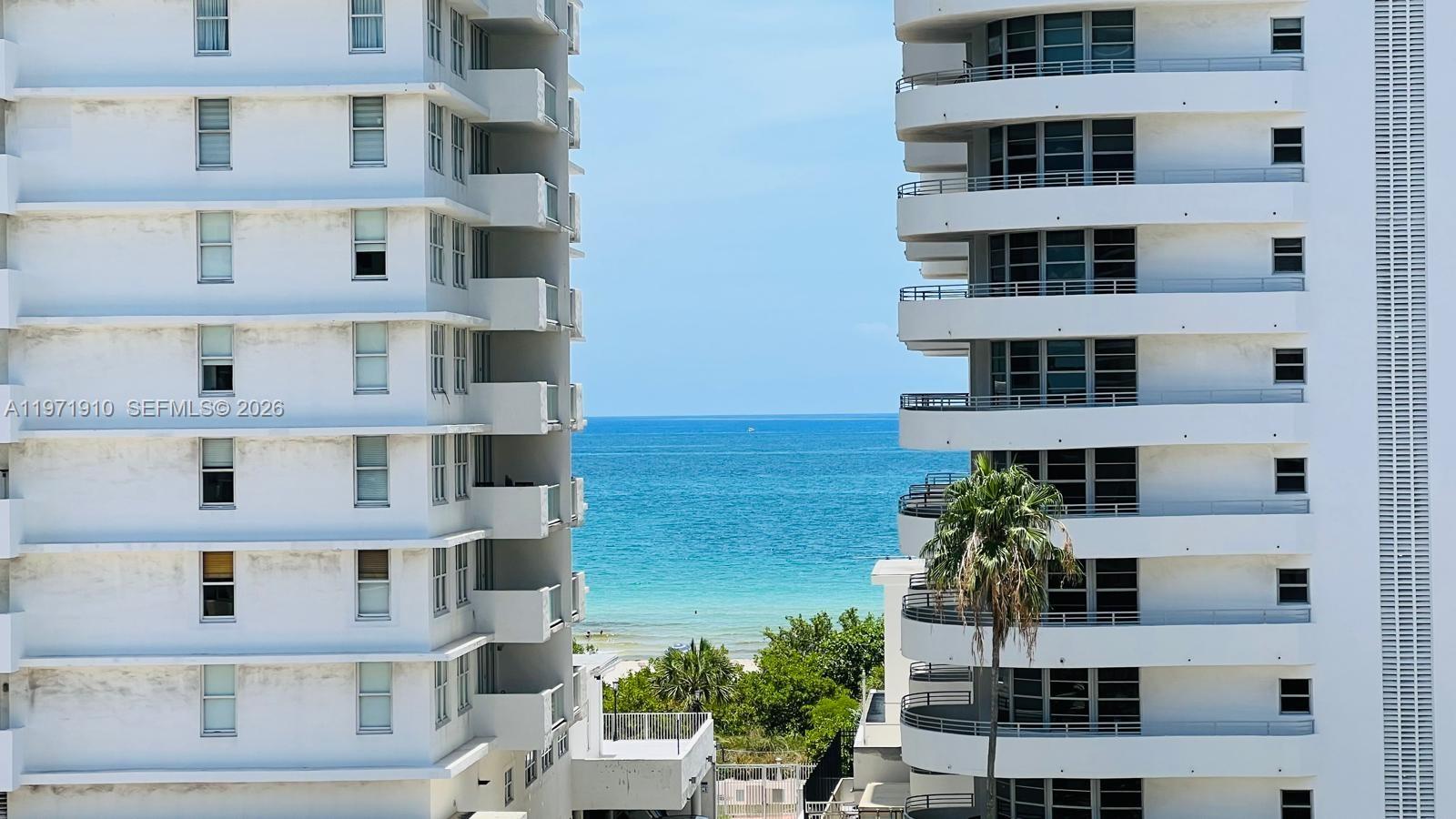 An exterior view of the ocean framed by two white high-rise residential buildings — 5600 Collins Ave # 7Y, Miami Beach FL 33140, MIAMI BEACH, FL