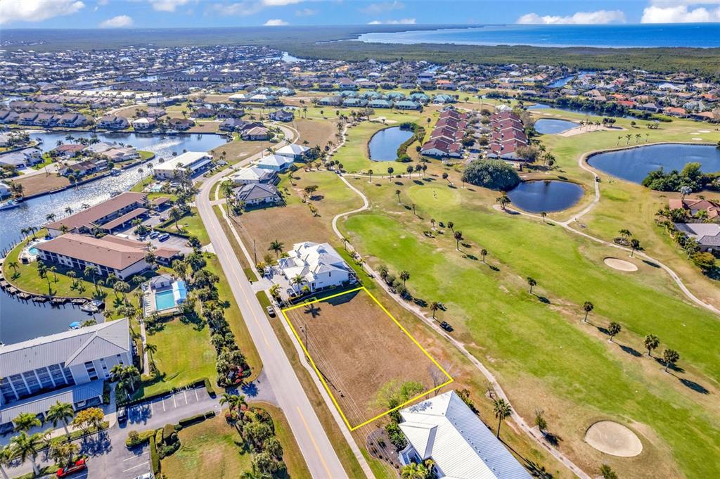 An aerial view shows a vacant rectangular lot outlined in yellow next to a golf course — 3639 BAL HARBOR BOULEVARD, PUNTA GORDA, FL