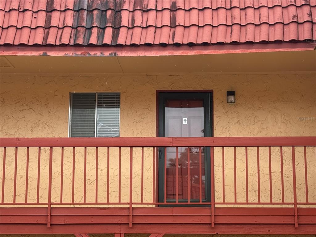 A balcony with a red railing, a window, and a door on a stucco building — 2800 N POWERS DRIVE UNIT 9, ORLANDO, FL
