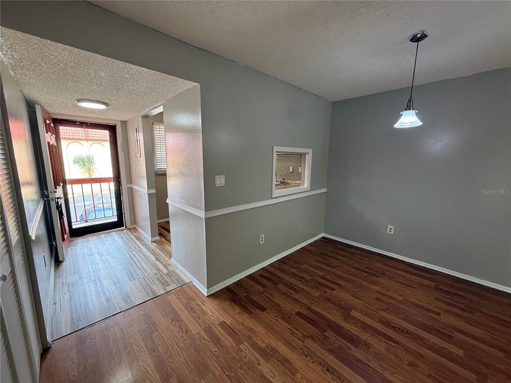 An interior view shows a dining area with wood-look flooring, gray walls, and a pass-through window — 2800 N POWERS DRIVE UNIT 9, ORLANDO, FL