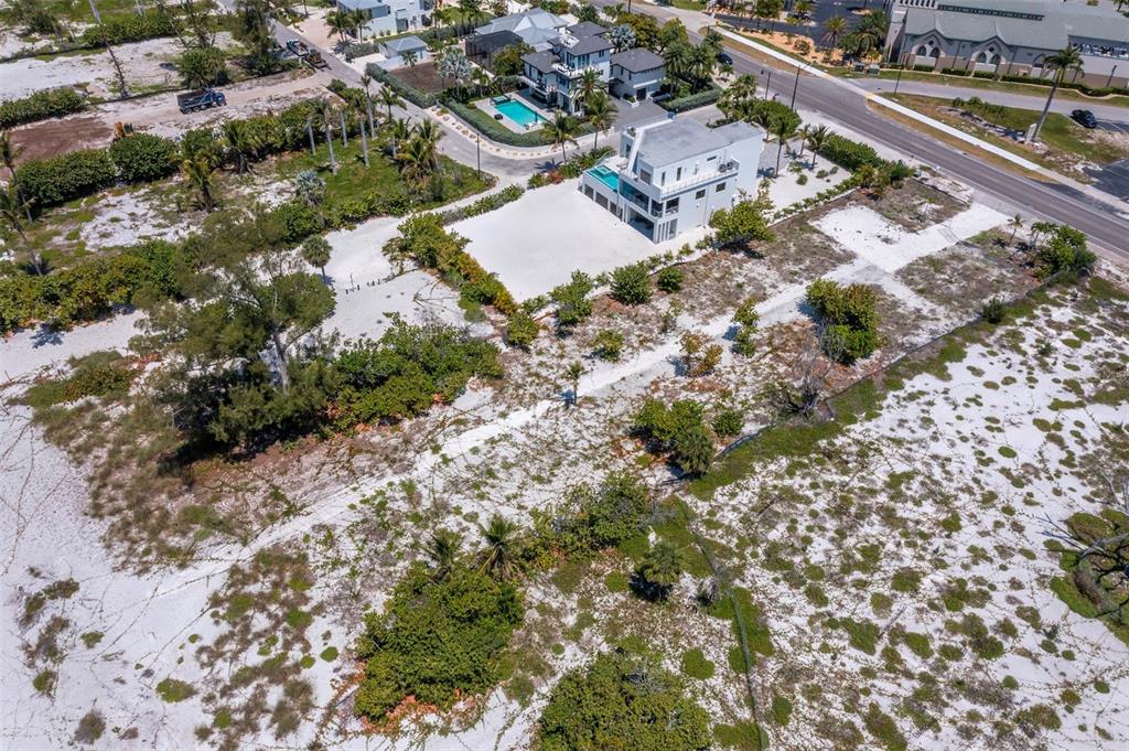 An aerial view shows a modern white house surrounded by sandy, undeveloped coastal land — 6351 GULF OF MEXICO DRIVE, LONGBOAT KEY, FL