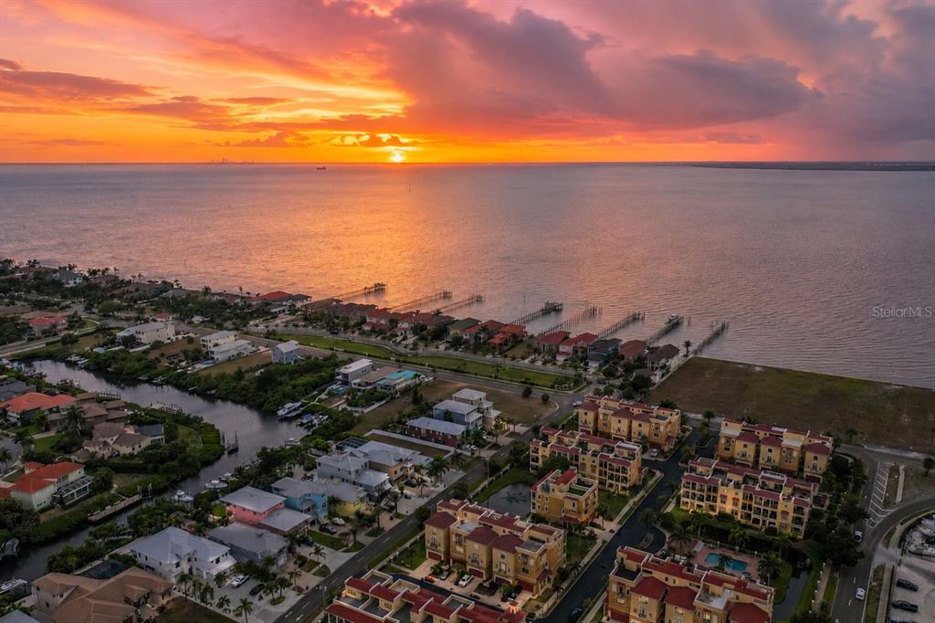 An aerial view of a coastal neighborhood at sunset with houses, docks, and a bay — 1340 APOLLO BEACH BOULEVARD S, APOLLO BEACH, FL