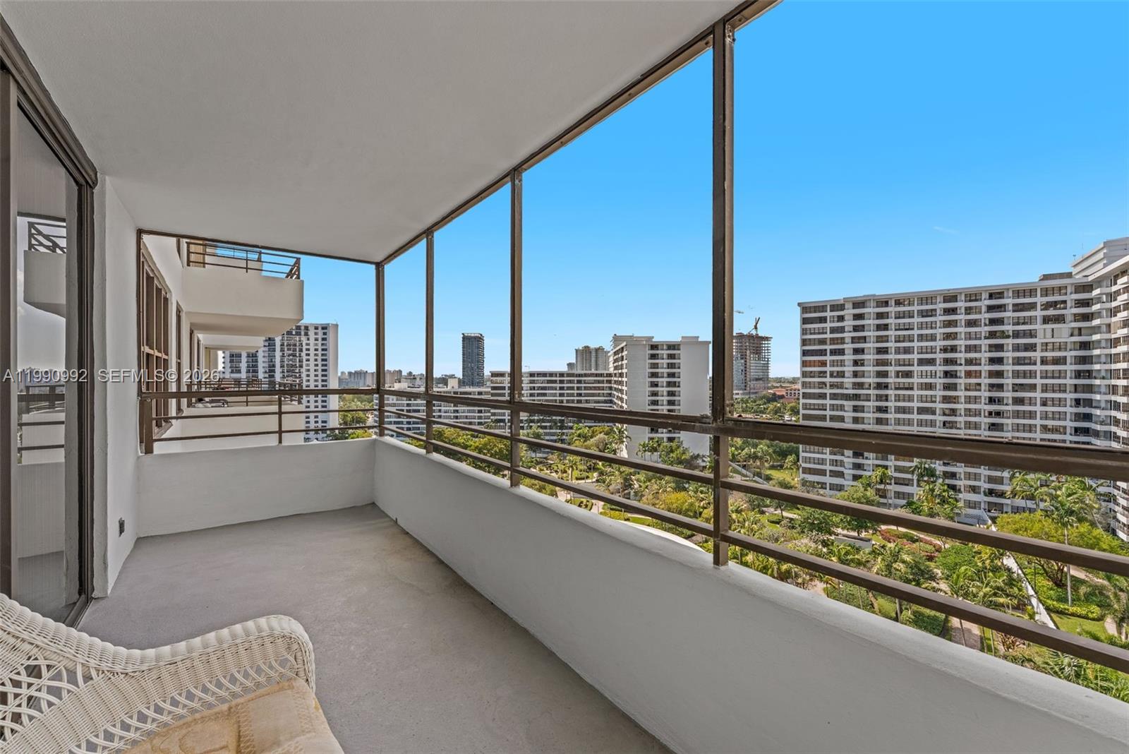A balcony with metal railings overlooks a view of surrounding apartment buildings and trees — 2500 PARKVIEW DR # 1418, Hallandale Beach FL 33009, HALLANDALE BEACH, FL