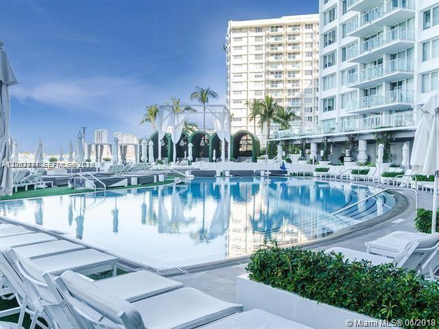 A swimming pool sits on a terrace next to a tall residential building — 1100 West Ave # 525, Miami Beach FL 33139, MIAMI BEACH, FL