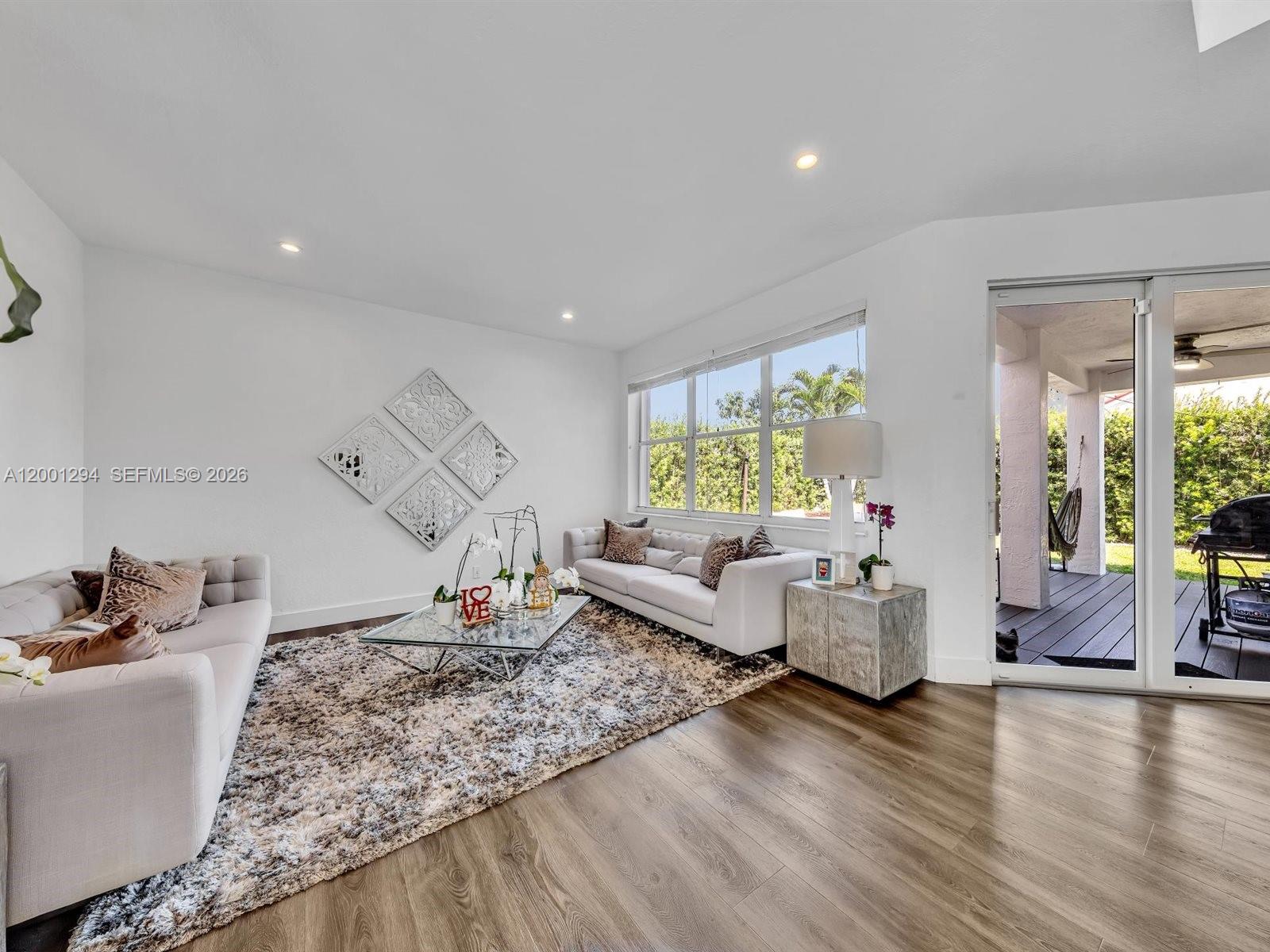 A living room features two sofas, a glass coffee table, and a sliding door to a patio — 1042 Thistle Creek Ct, Weston FL 33327, WESTON, FL